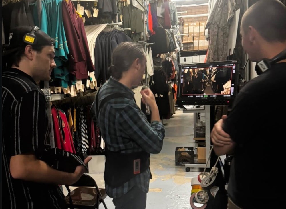 Crew watching the monitor between the costume racks