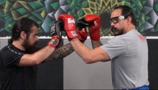 Fighters are squared off with gloves touching, trying to enter a clinch