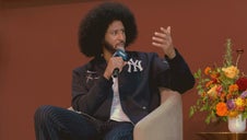 Colin Kaepernick gesturing as he speaks into a microphone on the Culture Stage at CultureCon 2026