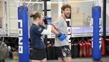 Fighter demonstrating a spinning back elbow as other fighter stays in high guard