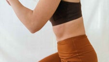 Woman doing a kneeling squat for postpartum strength training