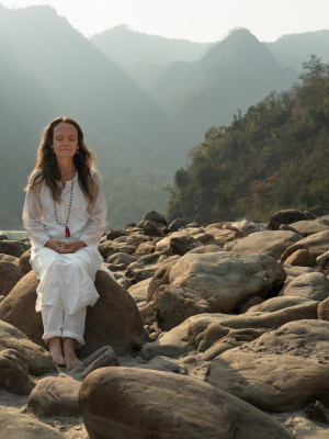 Woman meditating on a rock in India