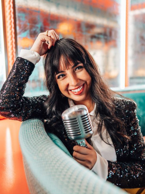 Smiling woman speaking into a microphone, representing photography business education and marketing.
