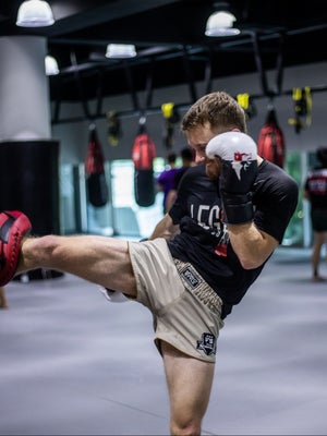 Man Kicking Muay Thai Pads
