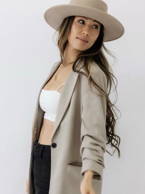 Kimmie Carter, Arizona photographer and educator, wearing a wide-brim hat and beige jacket, teaching how to shoot in harsh light and with VIP clients.