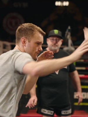 Fighter shadowboxing while his coach watches