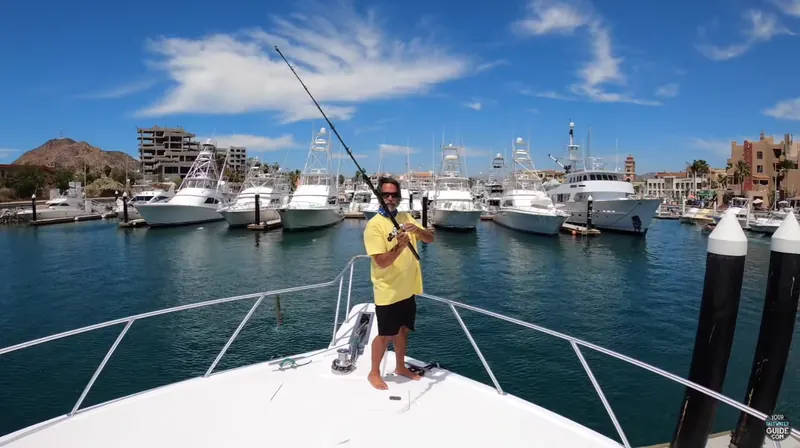 Captain Dave Hansen on the bow of a fishing boat in a marina