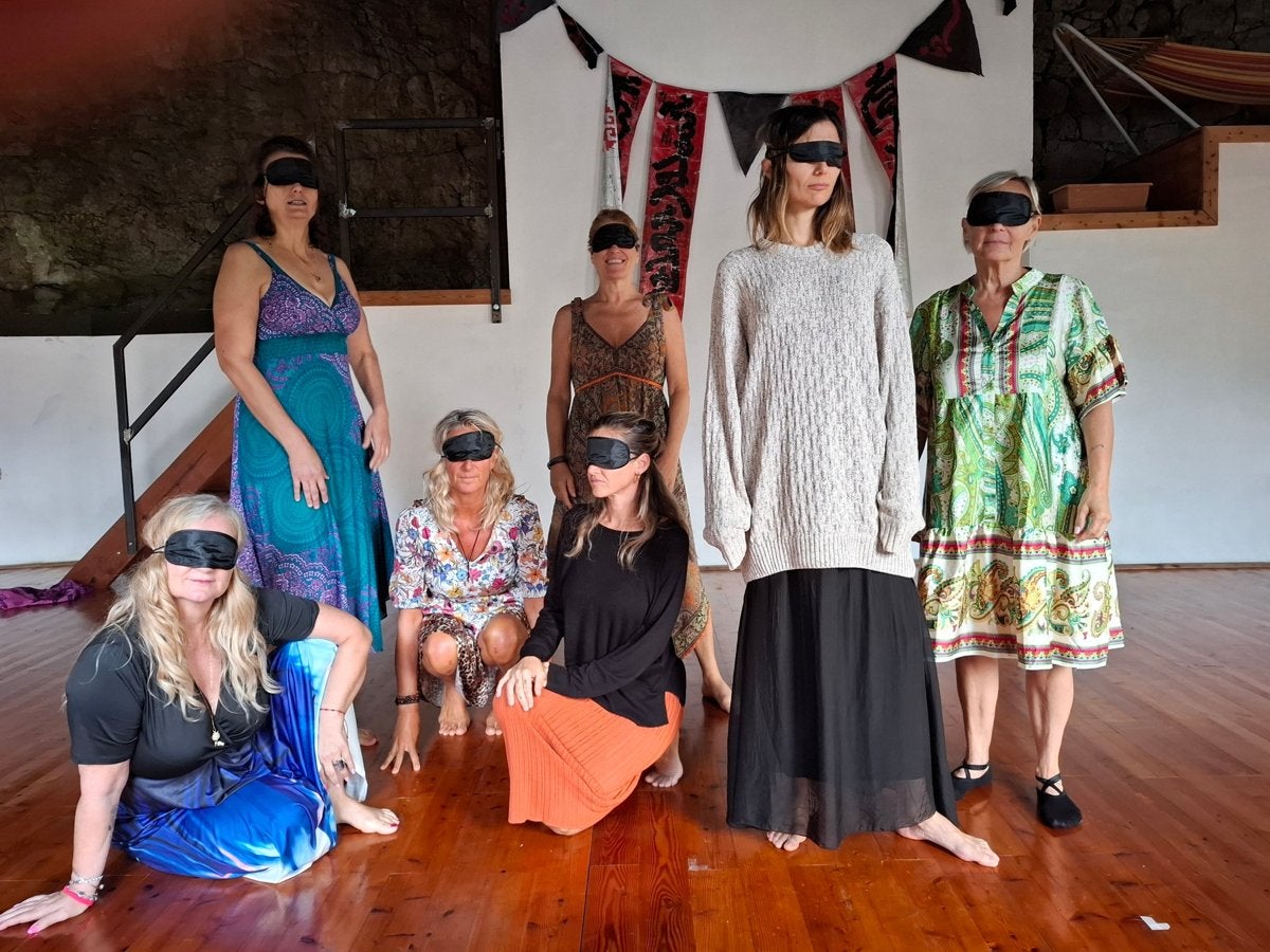 A group of guests wearing blindfolds during an inner work practice in the hall