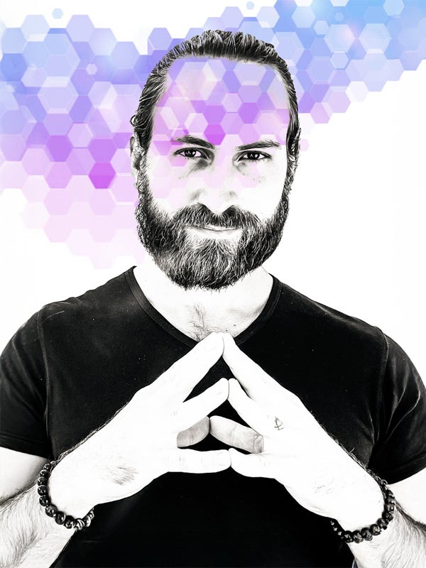 Andrew in black and white, hands in a mudra, with purple hexagons